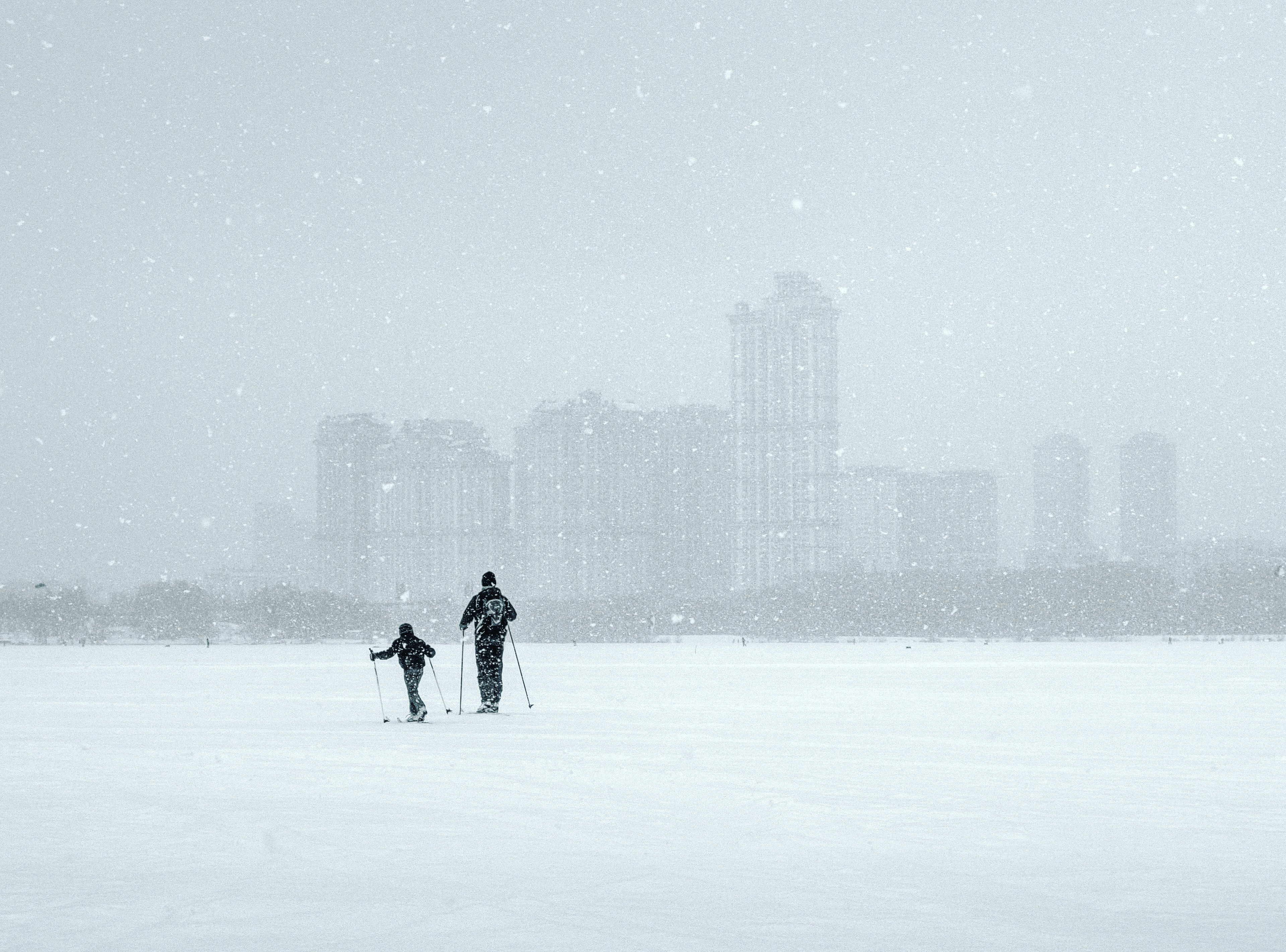 two persons walking on snow